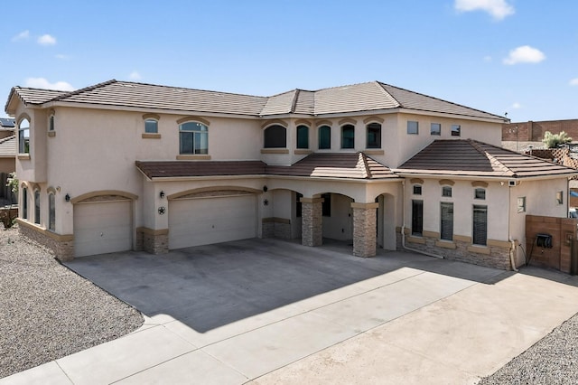 4420 Bentgrass Mdws NE, Rio Rancho, NM 87144 - mediterranean / spanish-style home with stucco siding, stone siding, a garage, driveway, and a tile roof