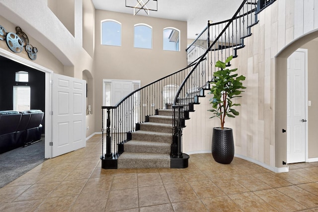 4420 Bentgrass Mdws NE, Rio Rancho, NM 87144 - foyer featuring a towering ceiling, stairs, light tile patterned floors, and arched walkways