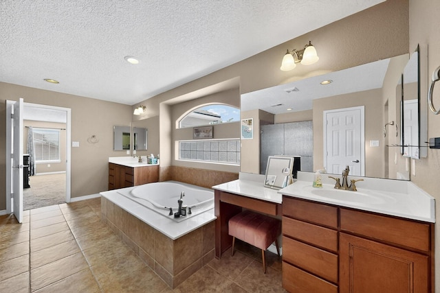 4420 Bentgrass Mdws NE, Rio Rancho, NM 87144 - bathroom featuring two vanities, a bath, tile patterned floors, a textured ceiling, and recessed lighting