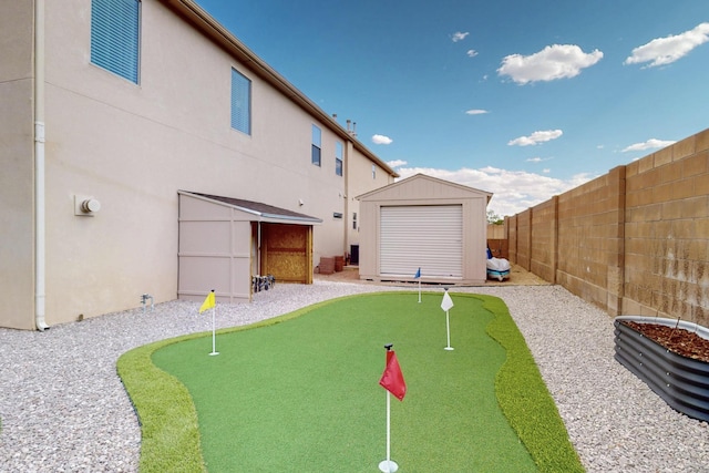 4420 Bentgrass Mdws NE, Rio Rancho, NM 87144 - rear view of property with an area to practice putting, a fenced backyard, a shed, and stucco siding