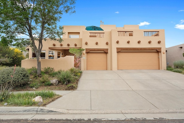 5808 Mariola Pl NE, Albuquerque, NM 87111 - pueblo-style home featuring concrete driveway, an attached garage, and stucco siding