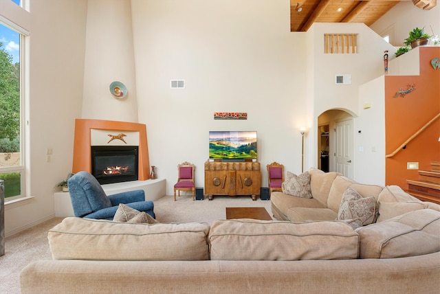 5808 Mariola Pl NE, Albuquerque, NM 87111 - living room with a towering ceiling, a wooden ceiling with exposed beams, carpet flooring, arched walkways, and a large fireplace