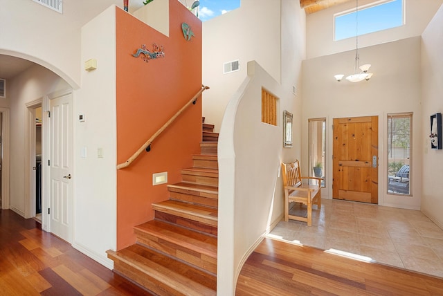 5808 Mariola Pl NE, Albuquerque, NM 87111 - foyer featuring arched walkways, a towering ceiling, plenty of natural light, stairs, and wood finished floors