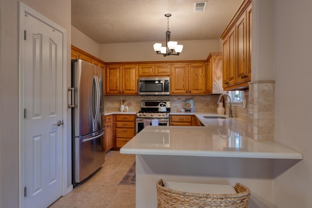 851 Vista Patron Dr, Bernalillo, NM 87004 - kitchen with stainless steel appliances, a peninsula, light countertops, decorative backsplash, and a textured ceiling