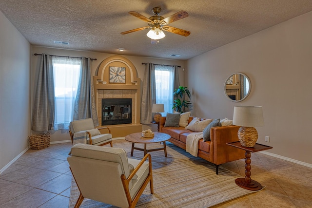 851 Vista Patron Dr, Bernalillo, NM 87004 - living area with plenty of natural light, a textured ceiling, tile patterned floors, ceiling fan, and a tiled fireplace