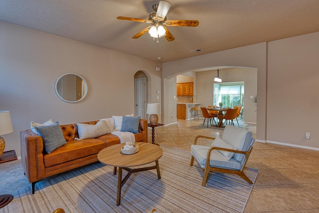 851 Vista Patron Dr, Bernalillo, NM 87004 - living area with arched walkways, ceiling fan, light tile patterned flooring, and a textured ceiling