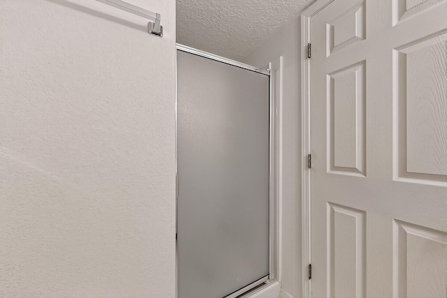 8905 Balsam Glade Rd NW, Albuquerque, NM 87114 - bathroom with a textured ceiling and a shower stall