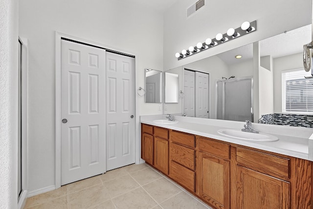 8905 Balsam Glade Rd NW, Albuquerque, NM 87114 - full bathroom featuring a shower stall, double vanity, tile patterned floors, and a closet