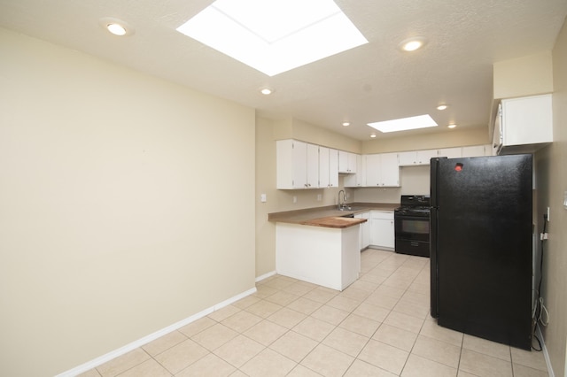 12910 Alice Ave NE, Albuquerque, NM 87112 - kitchen with black appliances, a skylight, white cabinetry, a peninsula, and recessed lighting