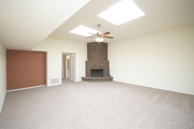 12910 Alice Ave NE, Albuquerque, NM 87112 - unfurnished living room featuring a skylight, carpet flooring, a brick fireplace, and ceiling fan