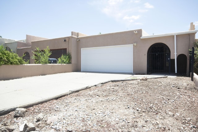 12910 Alice Ave NE, Albuquerque, NM 87112 - pueblo-style house with a garage, stucco siding, and driveway