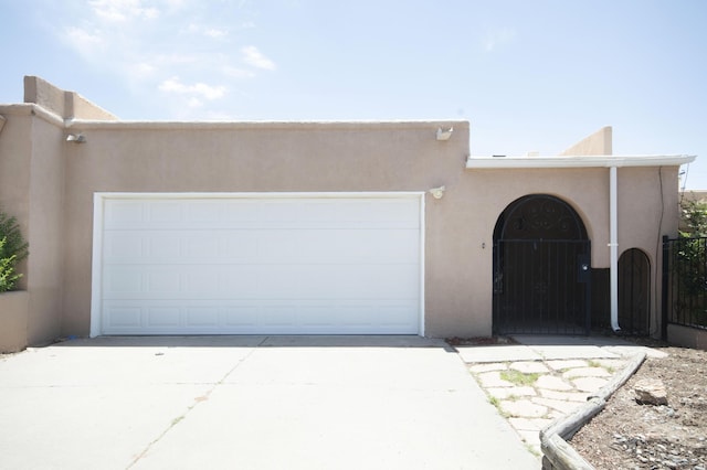 12910 Alice Ave NE, Albuquerque, NM 87112 - pueblo-style house with stucco siding, driveway, and a garage