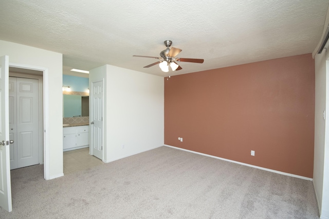 12910 Alice Ave NE, Albuquerque, NM 87112 - unfurnished bedroom with light colored carpet, a textured ceiling, a ceiling fan, and connected bathroom