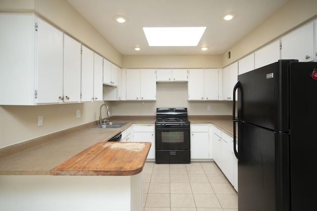 12910 Alice Ave NE, Albuquerque, NM 87112 - kitchen featuring black appliances, a peninsula, a skylight, light tile patterned floors, and recessed lighting