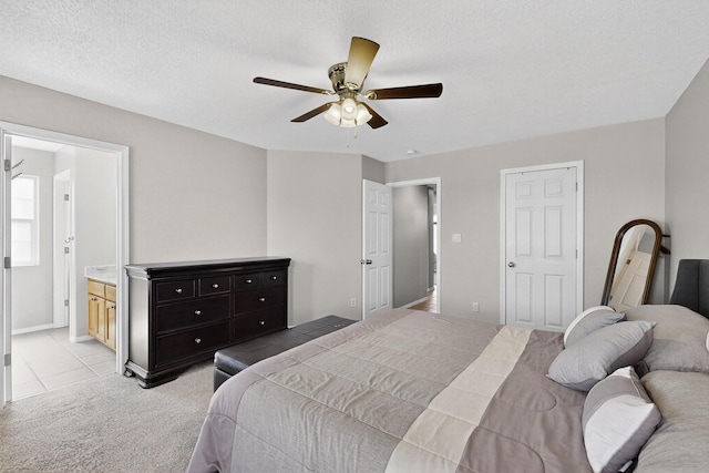 2062 Valley View Dr SW, Los Lunas, NM 87031 - bedroom with light colored carpet, connected bathroom, a textured ceiling, and ceiling fan