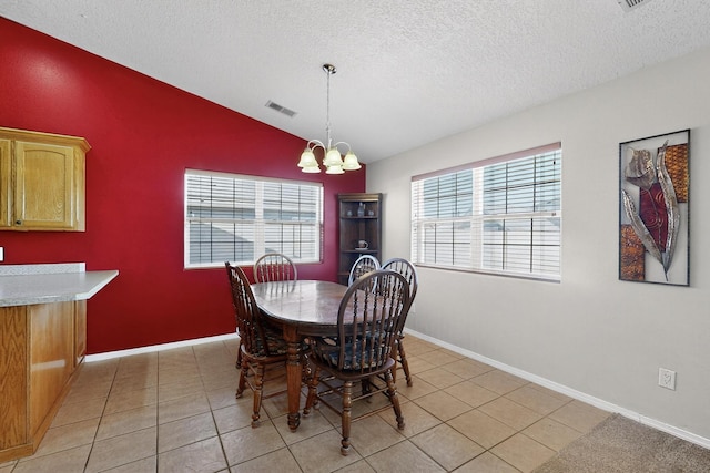 2062 Valley View Dr SW, Los Lunas, NM 87031 - dining area with vaulted ceiling, a chandelier, a textured ceiling, plenty of natural light, and light tile patterned floors