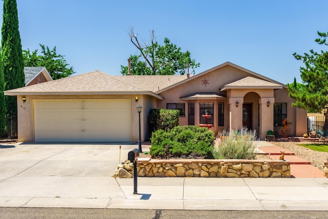 5131 Gaviota NW, Albuquerque, NM 87120 - view of front facade featuring stucco siding, an attached garage, concrete driveway, and roof with shingles