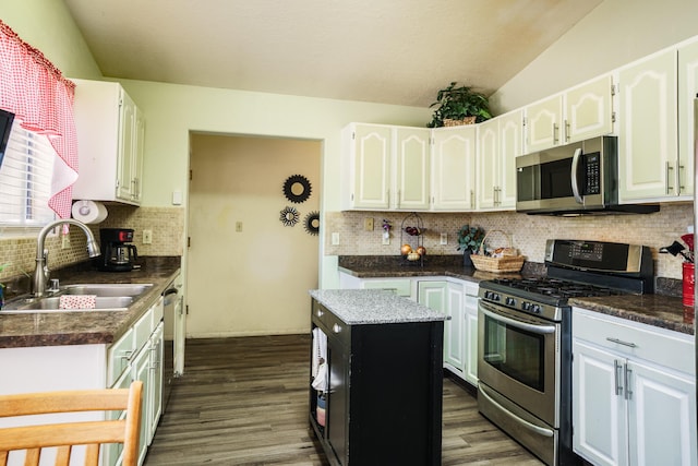 5131 Gaviota NW, Albuquerque, NM 87120 - kitchen with stainless steel appliances, dark wood-style floors, vaulted ceiling, backsplash, and white cabinetry