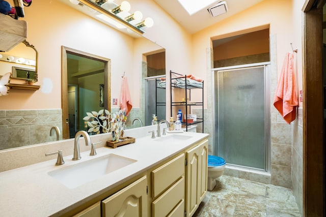 5131 Gaviota NW, Albuquerque, NM 87120 - full bathroom featuring tile walls, a shower stall, double vanity, and wainscoting