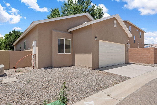 5723 Strand Loop SE, Albuquerque, NM 87106 - view of front of house with stucco siding, an attached garage, and driveway