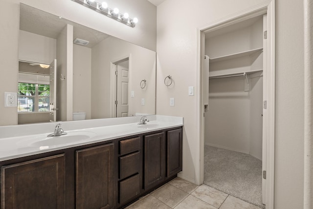 5723 Strand Loop SE, Albuquerque, NM 87106 - bathroom featuring tile patterned floors, double vanity, and a walk in closet