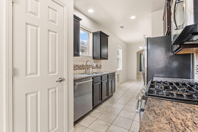 5723 Strand Loop SE, Albuquerque, NM 87106 - kitchen featuring appliances with stainless steel finishes, decorative backsplash, light tile patterned floors, light stone counters, and recessed lighting