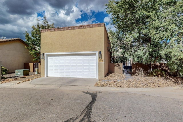 5716 Strand Loop SE, Albuquerque, NM 87106 - pueblo-style home featuring stucco siding, concrete driveway, and an attached garage
