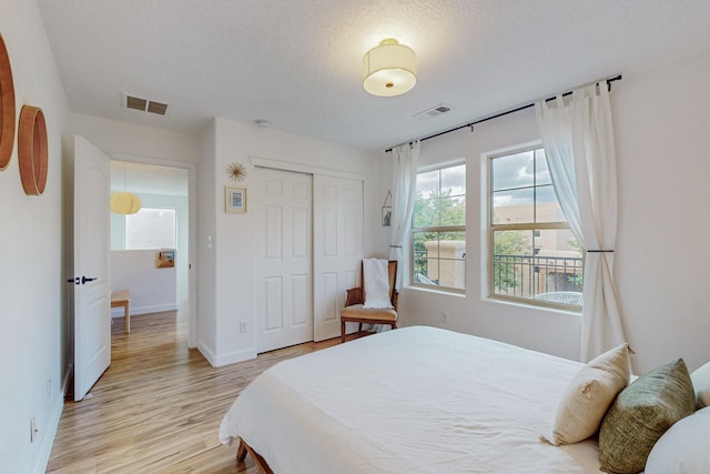 5716 Strand Loop SE, Albuquerque, NM 87106 - bedroom featuring light wood-style flooring, a closet, and a textured ceiling