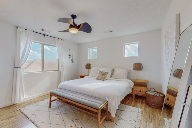 5716 Strand Loop SE, Albuquerque, NM 87106 - bedroom with multiple windows, light wood-style floors, and a ceiling fan