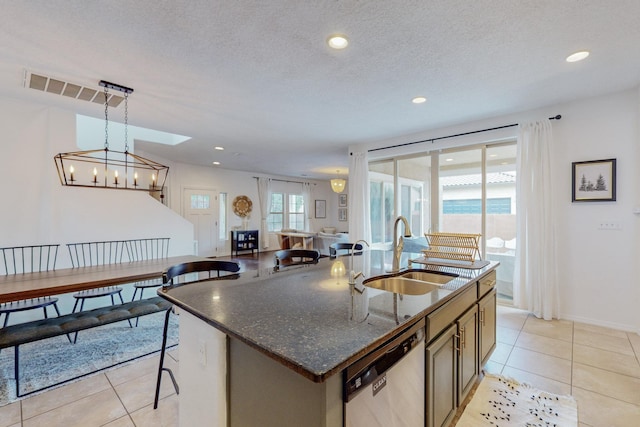 5716 Strand Loop SE, Albuquerque, NM 87106 - kitchen with dishwasher, light tile patterned floors, a center island with sink, dark stone counters, and recessed lighting