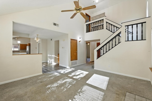 7816 Bursera Dr NW, Albuquerque, NM 87120 - unfurnished living room with carpet flooring, a chandelier, high vaulted ceiling, ceiling fan, and stairs