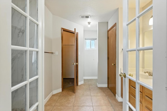 7816 Bursera Dr NW, Albuquerque, NM 87120 - hall featuring light tile patterned floors and french doors