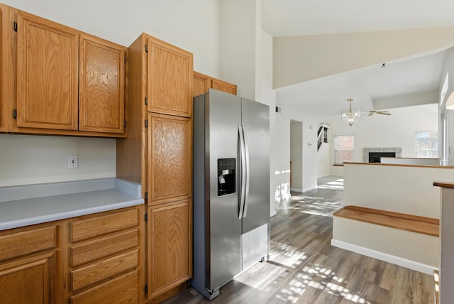 7816 Bursera Dr NW, Albuquerque, NM 87120 - kitchen featuring stainless steel fridge with ice dispenser, high vaulted ceiling, dark wood-style floors, open floor plan, and brown cabinets