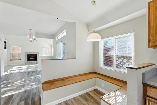7816 Bursera Dr NW, Albuquerque, NM 87120 - unfurnished dining area featuring lofted ceiling, wood finished floors, a chandelier, and a fireplace