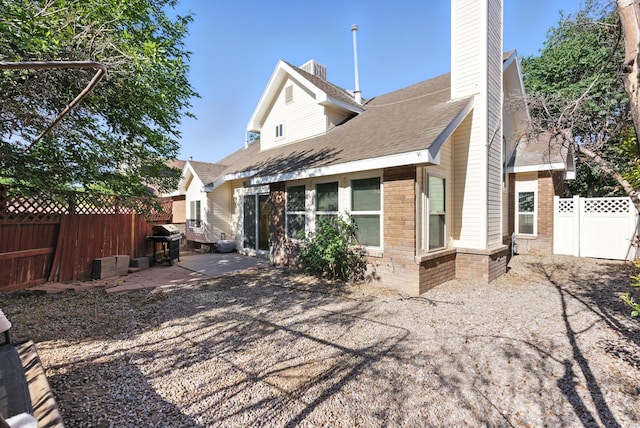 7816 Bursera Dr NW, Albuquerque, NM 87120 - back of property with a chimney, brick siding, a patio area, a fenced backyard, and roof with shingles