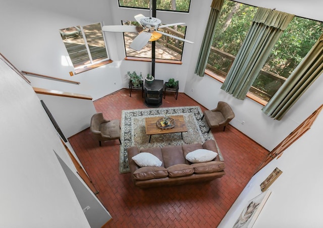113 Sandia Crest Rd, Sandia Park, NM 87047 - living area featuring brick floors, a wood stove, and a ceiling fan