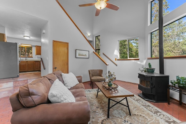 113 Sandia Crest Rd, Sandia Park, NM 87047 - living area with a wood stove, a high ceiling, and a ceiling fan
