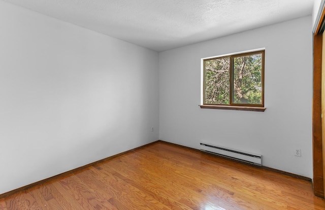 113 Sandia Crest Rd, Sandia Park, NM 87047 - empty room featuring a baseboard heating unit and light wood finished floors