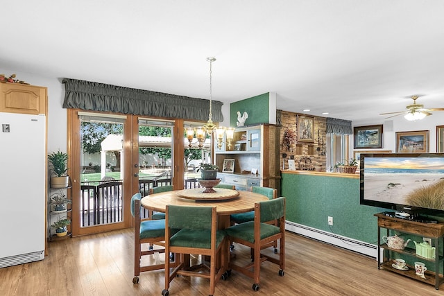 40 La Bajada Rd, Los Lunas, NM 87031 - dining room with a baseboard heating unit, light wood-type flooring, a ceiling fan, and a chandelier