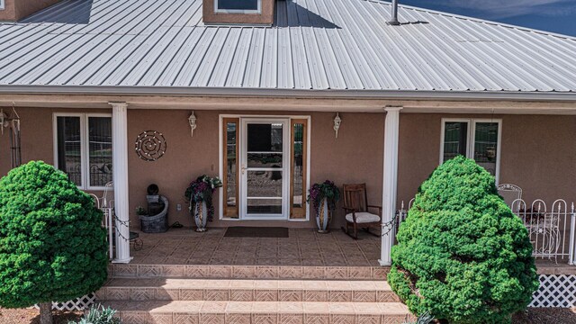 40 La Bajada Rd, Los Lunas, NM 87031 - property entrance with a porch, a metal roof, and stucco siding