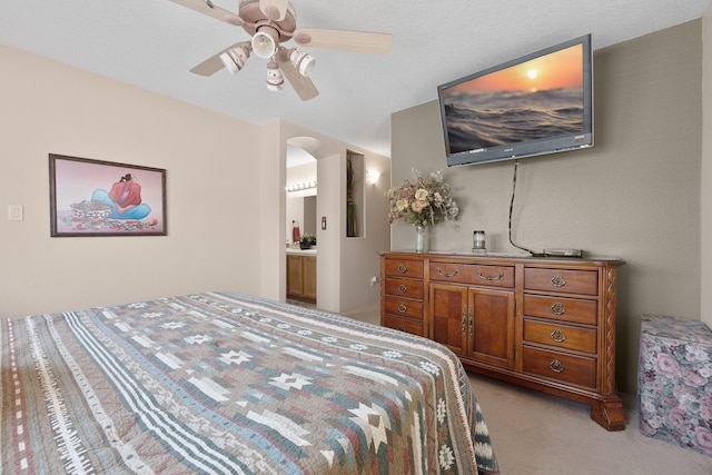 10027 Vista Cantera Ln NW, Albuquerque, NM 87114 - bedroom featuring light carpet, arched walkways, ceiling fan, and ensuite bath