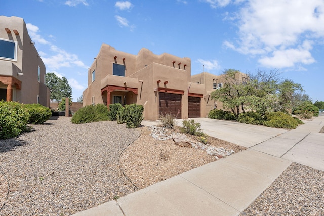 10027 Vista Cantera Ln NW, Albuquerque, NM 87114 - pueblo-style house with stucco siding, a garage, and driveway