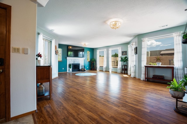 5 Ocotillo Way, Placitas, NM 87043 - living area with a tiled fireplace, wood finished floors, and a textured ceiling