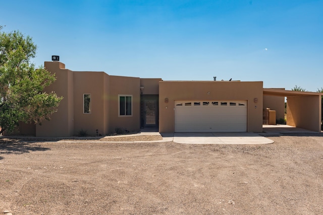 5 Ocotillo Way, Placitas, NM 87043 - pueblo-style home with driveway, an attached garage, and stucco siding