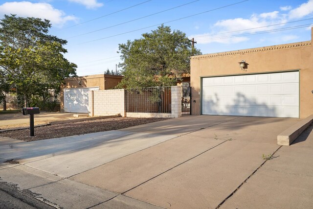 504 Ortiz Dr NE, Albuquerque, NM 87108 - view of front of house with stucco siding, concrete driveway, and a garage