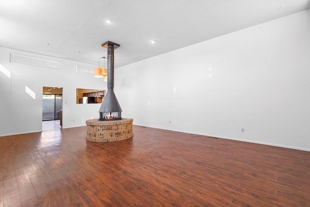 504 Ortiz Dr NE, Albuquerque, NM 87108 - unfurnished living room featuring dark wood-style floors, a wood stove, and recessed lighting