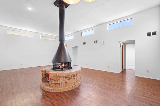 504 Ortiz Dr NE, Albuquerque, NM 87108 - living room with a wood stove, wood finished floors, and a high ceiling
