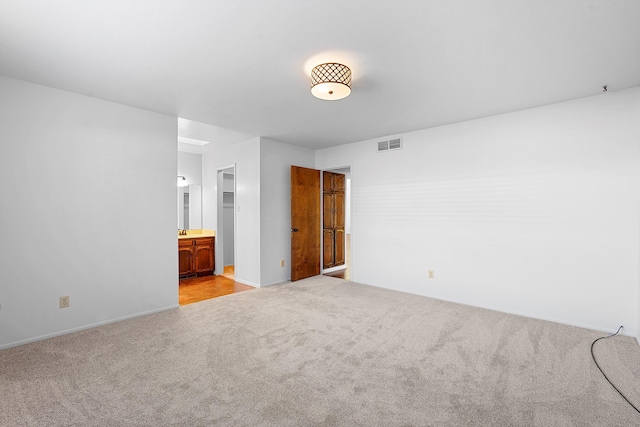 504 Ortiz Dr NE, Albuquerque, NM 87108 - unfurnished bedroom featuring light colored carpet and connected bathroom