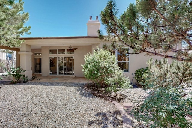 13100 Desert Moon Pl NE, Albuquerque, NM 87111 - back of property with a ceiling fan, a chimney, stucco siding, and a patio