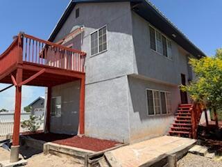 4 Los Chavez Park Rd, Belen, NM 87002 - rear view of house featuring stairway, a wooden deck, and stucco siding